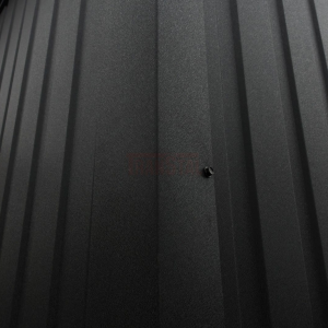 Angled close-up of matte black corrugated metal siding with a visible wall screw.